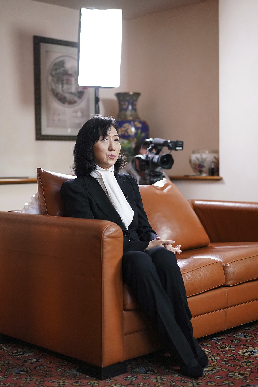 Grace Meng, the wife of former Interpol president Meng Hongwei, answers the Associated Press in Lyon, central France, Tuesday, Nov. 16, 2021. In the exclusive interview, Meng chose to show her face for the first time since her husband disappeared in China in 2018, agreeing to be filmed and photographed without the dark lighting and from-the-back camera angles that she had previously insisted on. She did so to be able to speak openly and in unprecedented detail about her husband's imprisonment, herself and the cataclysm that tore them apart. (AP Photo/Laurent Cipriani)
