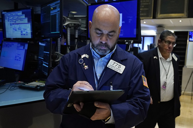 Trader Fred DeMarco, left, works on the floor of the New York Stock Exchange, Friday, Nov. 19, 2021. Stocks are off to a mostly lower start on Wall Street Friday, though gains for some big technology companies are sending the Nasdaq a bit higher. (AP Photo/Richard Drew)