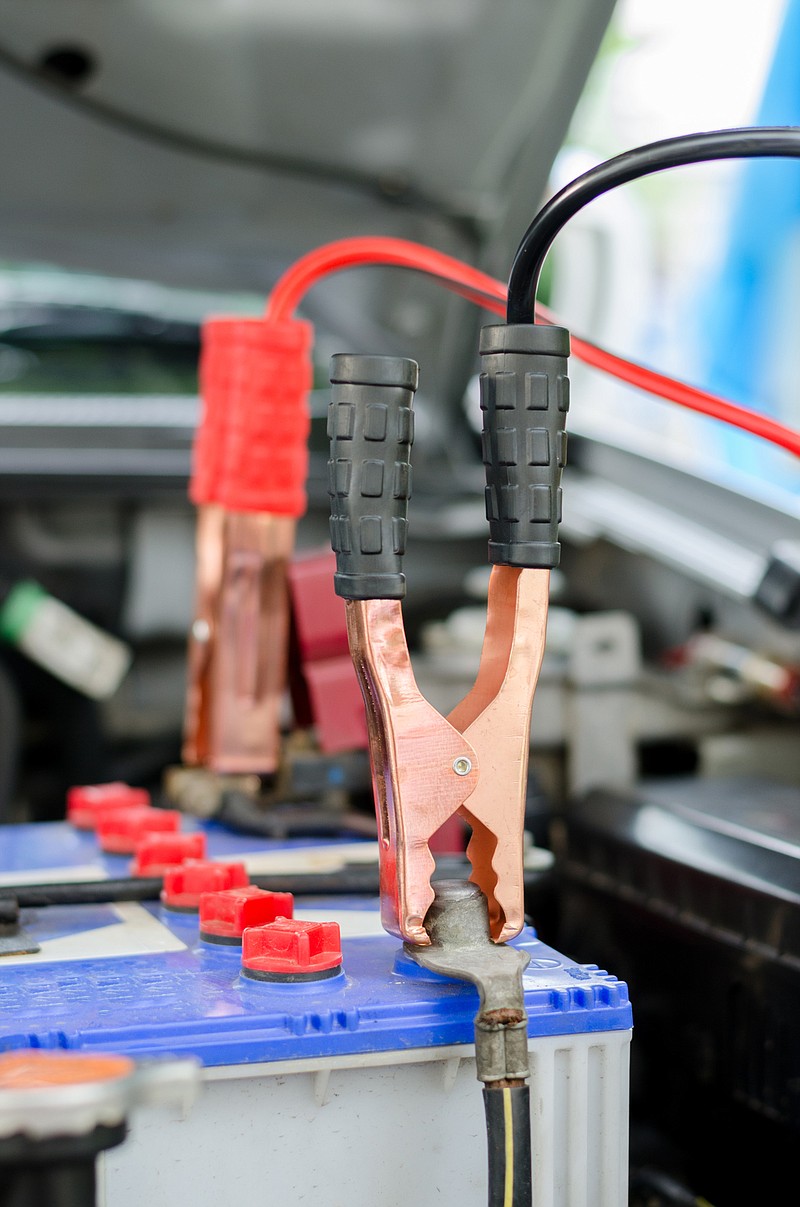 Jumper cables attached to a car battery. If you leave your hybrid at home, the winter cold will take a toll, writes Bob Weber. (Dreamstime/TNS)