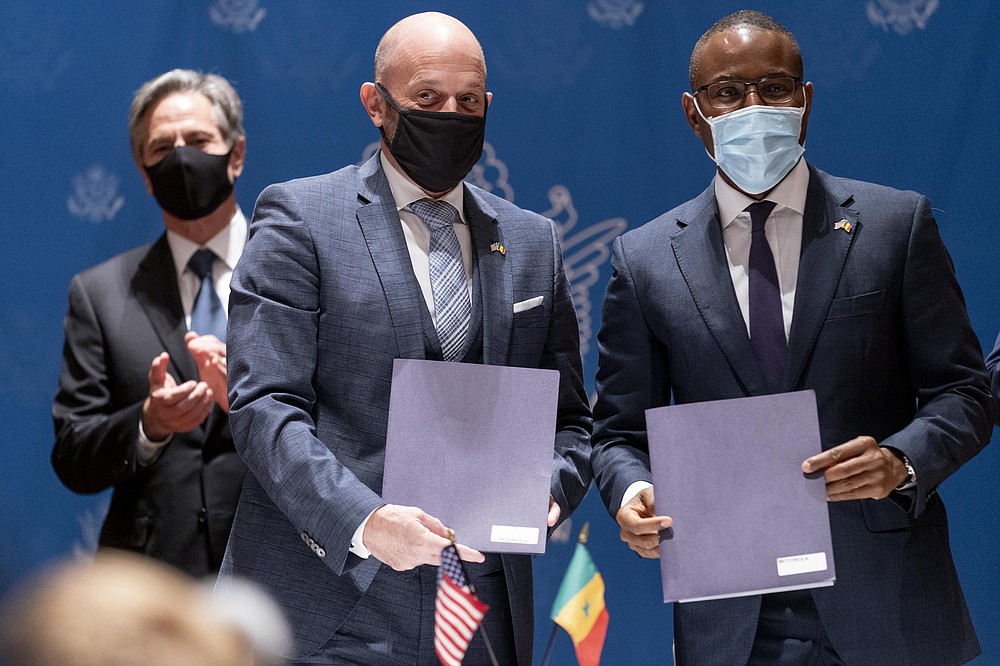 US Secretary of State Antony Blinken, left, applauds as Motorola Solutions Vice President for Africa and the Middle East Patrick Fitting, second from left, and Senegal's Minister of Economy, Planning and International Cooperation Amadou Hott, pose for photographs after signing an agreement during a commercial diplomacy event with U.S. companies and the government of Senegal a meeting at the Radisson Blu Hotel in Dakar, Nigeria, Saturday, Nov. 20, 2021. Blinken is on a five day trip to Kenya, Nigeria, and Senegal. (AP Photo/Andrew Harnik, Pool)