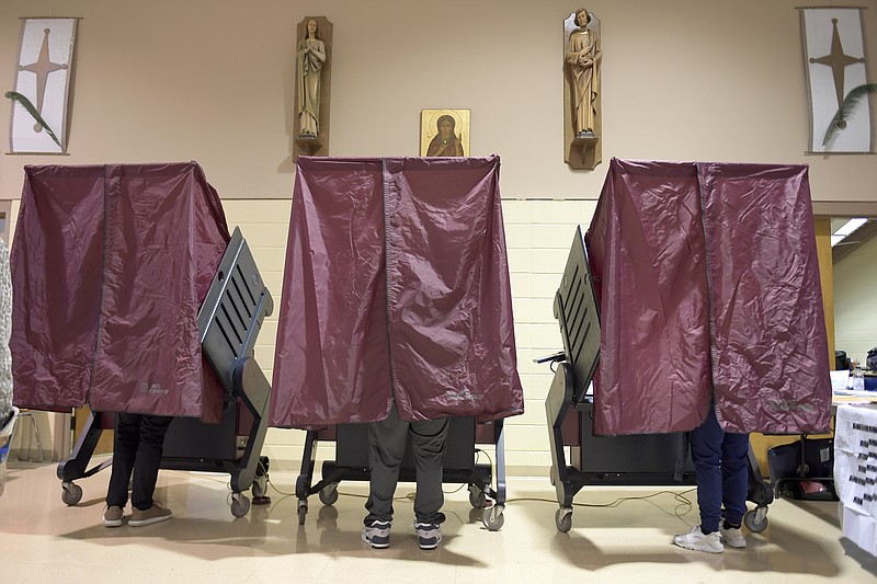 FILE - In this Tuesday, Nov. 3, 2020 file photo, Voters occupy booths at St. Maria Goretti Church, where five voting precincts are located, as polls open for Election Day in New Orleans. After a five-week postponement, early voting begins Saturday, Oct. 30, 2021 in Louisiana&#x2019;s hurricane-delayed fall election, with four constitutional amendments the only thing facing all voters statewide.(Max Becherer/The Advocate via AP, File)