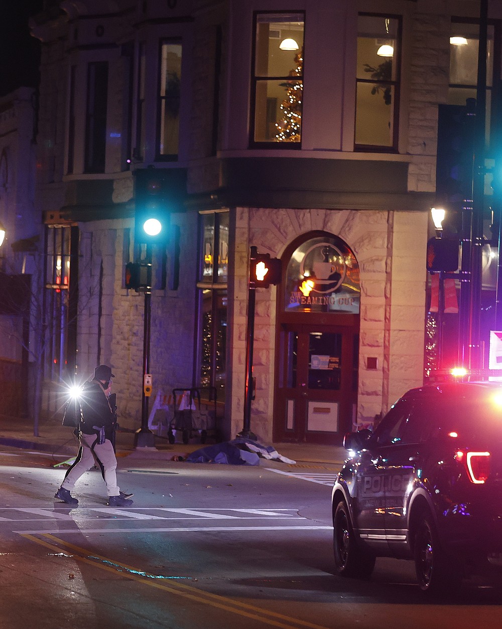 Police canvass the streets in downtown Waukesha, Wis., after a vehicle plowed into a Christmas parade hitting multiple people Sunday, Nov. 21, 2021. (AP Photo/Jeffrey Phelps)