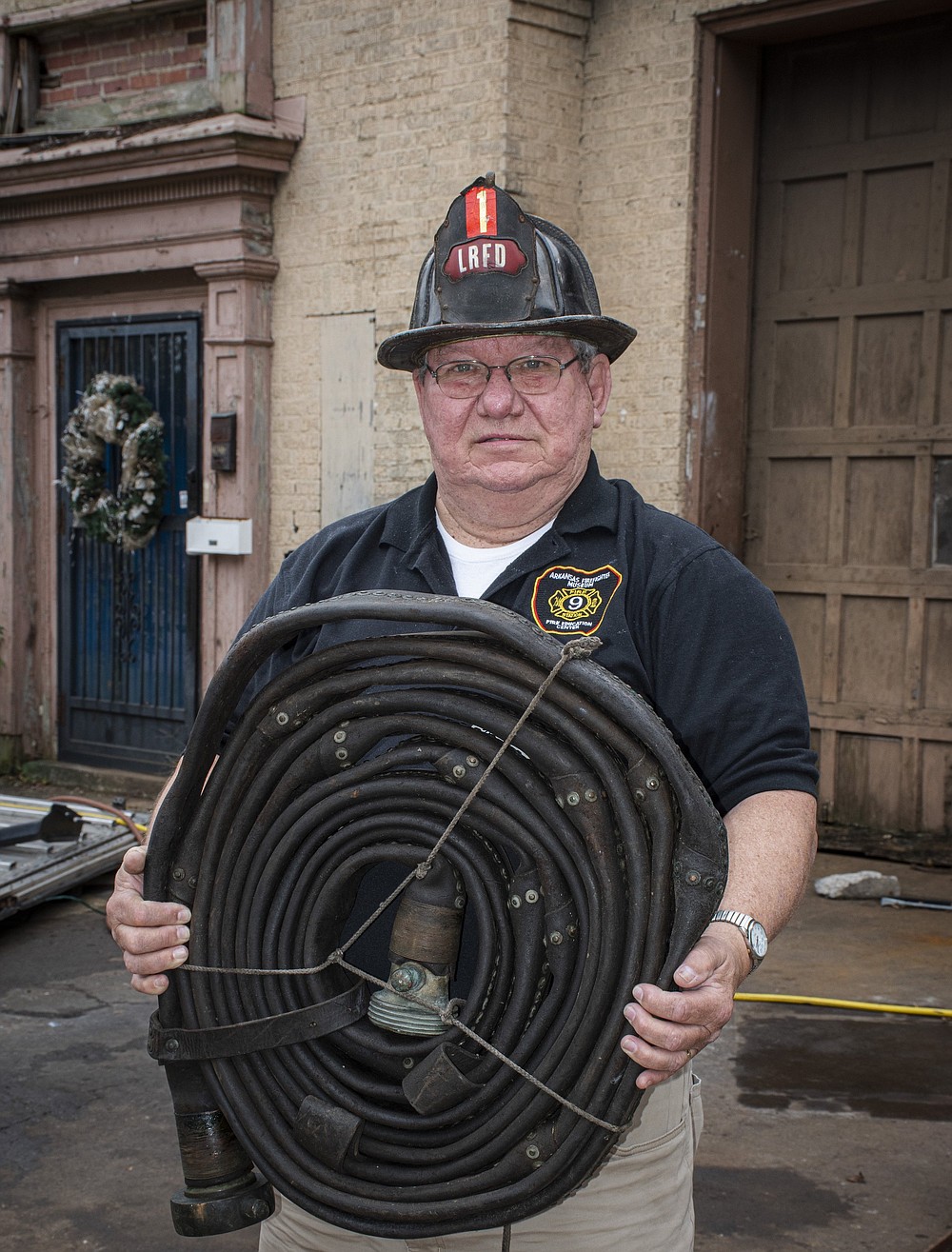 Wearing a historic leather helmet and holding an 1840-vintage leather fire hose, Bob Franklin stands outside the 1930 firehouse on East Sixth Street, where he hopes to create a the Arkansas Firefighter Museum and Fire Education Center.

(Arkansas Democrat-Gazette/Cary Jenkins)