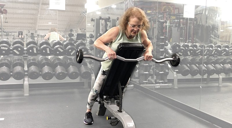 Beverly Lindberg demonstrates the Incline Barbell Pause Row for Matt Parrott's Master Class at Little Rock Athletic Club. (Arkansas Democrat-Gazette/Celia Storey)