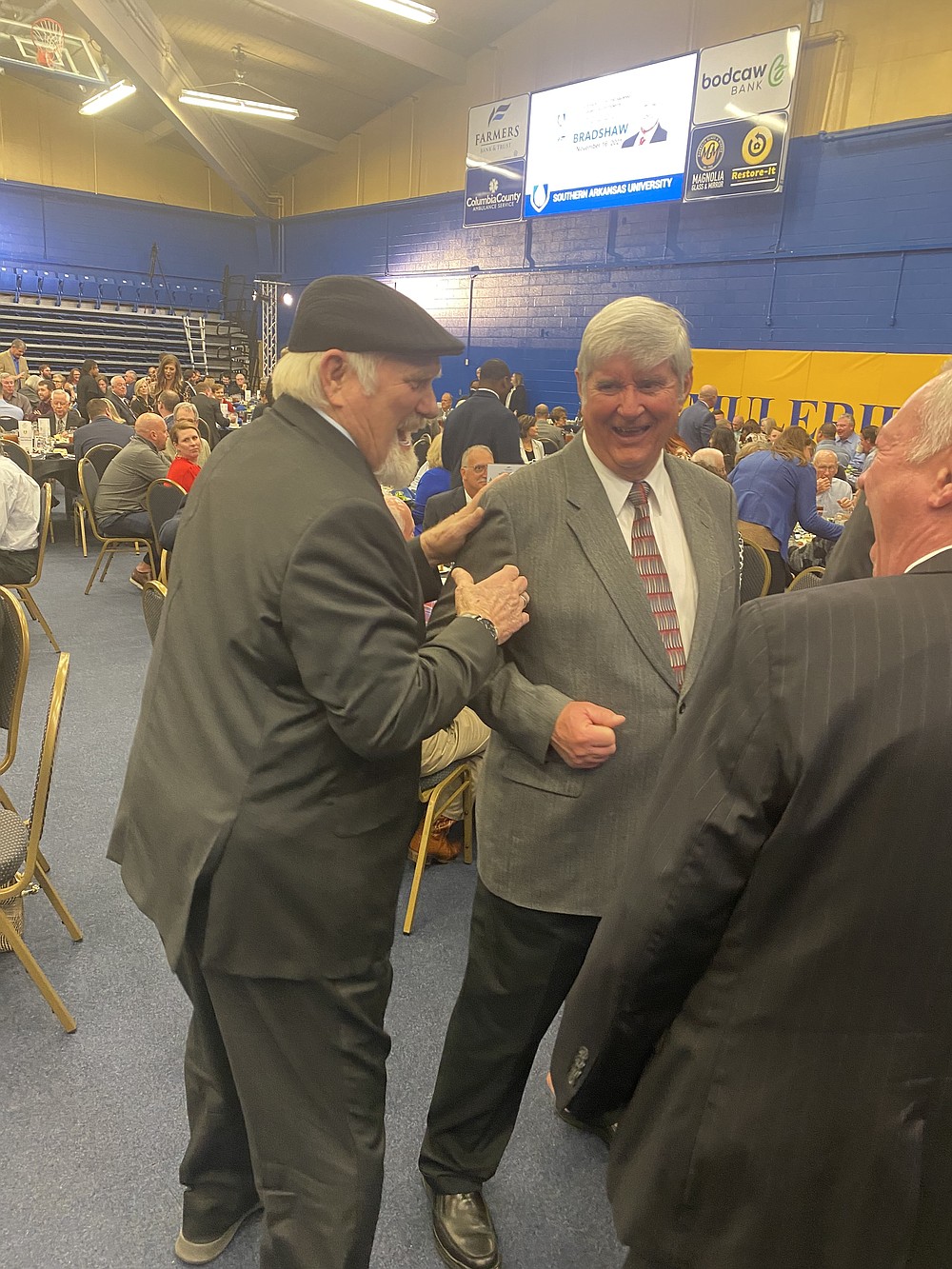 Terry Bradshaw, left, speaking with attendees from Farmers Bank &  Trust our premium speaker chain as it walks into place on the podium.  (Becky Bell/News Times)