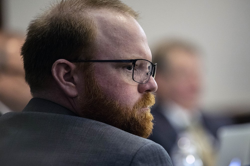 Travis McMichael sits with his attorneys before the start of closing arguments to the jury during the trial of he, and his father Greg McMichael, and William "Roddie" Bryan, at the Glynn County Courthouse, Monday, Nov. 22, 2021, in Brunswick, Ga. The three men charged with the February 2020 slaying of 25-year-old Ahmaud Arbery. (AP Photo/Stephen B. Morton, Pool)