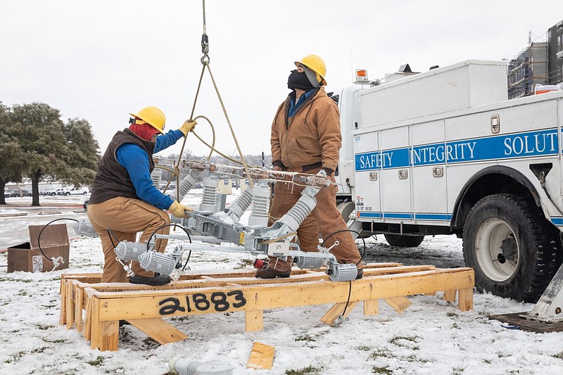 Workers repair a power line in Austin, Texas, on Feb. 18, 2021. MUST CREDIT: Bloomberg photo by Thomas Ryan Allison.