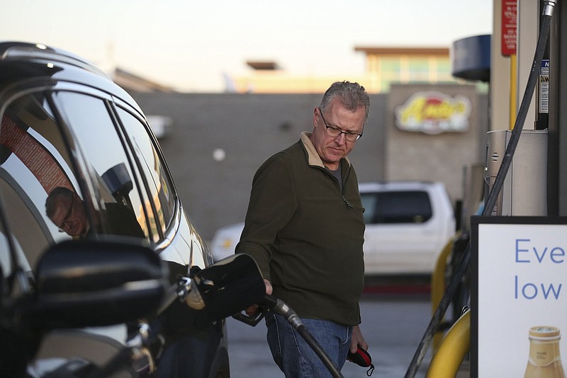 David Chapman of Rogers pumps gas, Monday, November 22, 2021 at the Walmart Neighborhood Market gas station in Rogers. Travel this Thanksgiving week is expected to hit near peak numbers despite high gas prices and climbing pandemic numbers. Check out nwaonline.com/211123Daily/ for today's photo gallery. 
(NWA Democrat-Gazette/Charlie Kaijo)