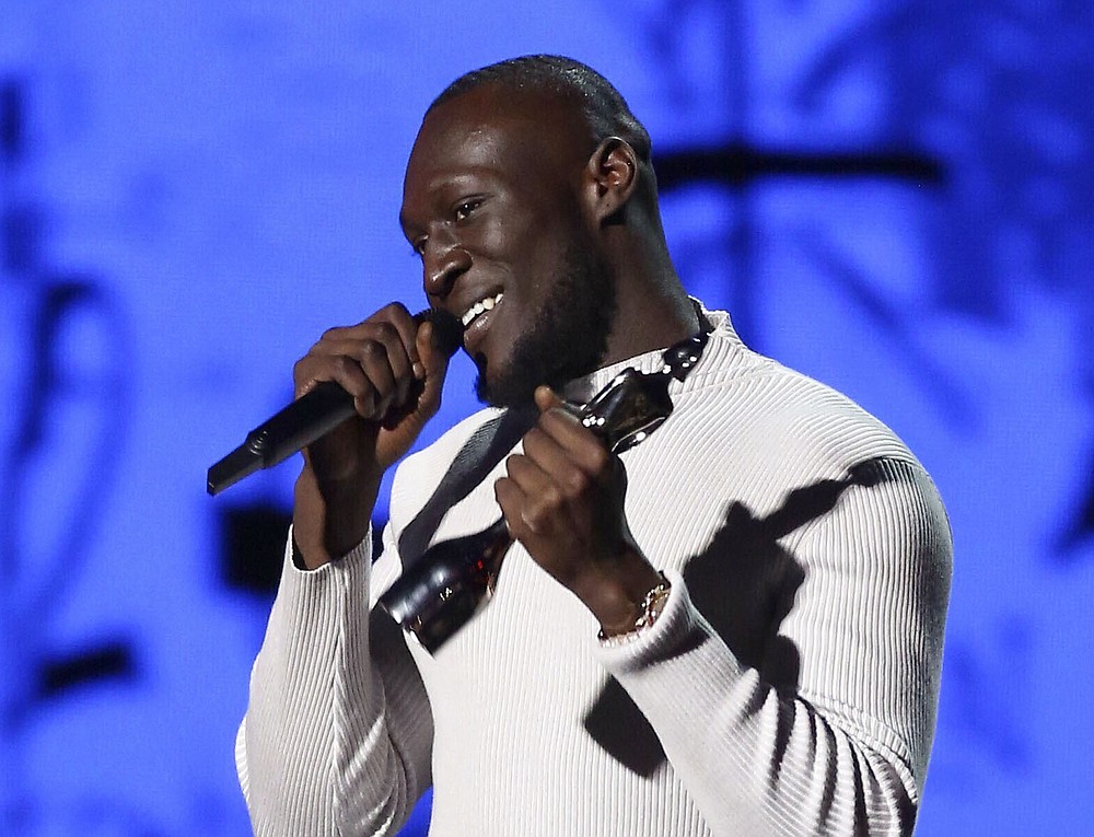 FILE - Stormzy accepts his award for Male Solo Artist of the Year on stage at the Brit Awards 2020 in London, Feb. 18, 2020. Jan. 26, 2020 file photo shows. The organizers of the Brit Awards announced Monday Nov. 22, 2021, they are scrapping separate male and female artist categories in a shakeup designed to make the music prizes more inclusive. (Photo by Joel C Ryan/Invision/AP, File)