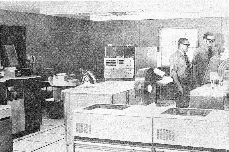 Courtesy Bella Vista Historical Museum This view of the data processing department of Cooper Communities, Inc., at Bella Vista shows a segment of the new IBM equipment presently in use. Seated is Travis Hitt, operator, and standing are (left) Wayne Phillips, director of data processing, and James Green, programmer.