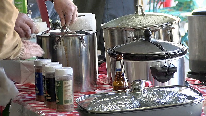 Teams prepare their pots of chili prior to the start of the annual Tom Daniel Holiday Chili Cook-Off on Monday at Exchange Street Parking Plaza. - Photo by Tyler Wann of The Sentinel-Record