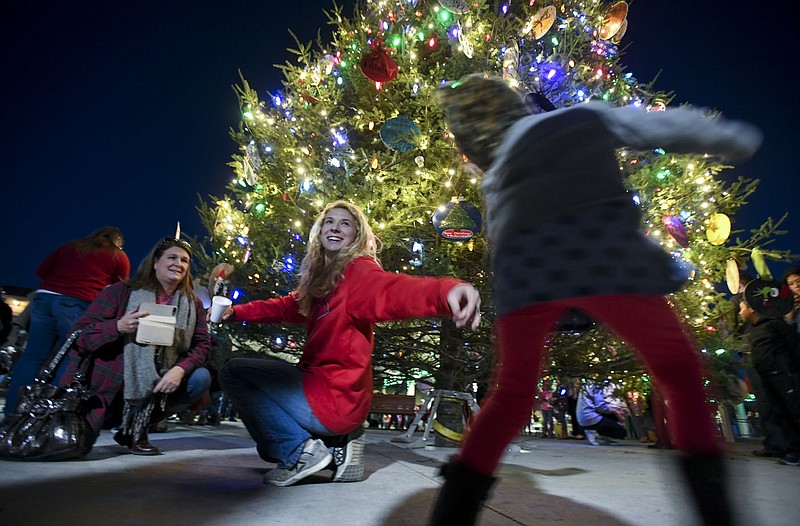 NWA Democrat-Gazette/CHARLIE KAIJO Amanda Ward of Fayetteville reaches for Leighann Ward, 3 in front of a large lit Christmas tree during the 2nd annual Christmas on The Creek on Saturday, November 25, 2017 at Shiloh Square in Springdale. Springdale celebrated it&#x2019;s 2nd annual holiday tradition, &quot;Christmas on the Creek&quot;, which included photos with Santa, mini train rides,  the lighting of the region's largest live community Christmas tree and a parade