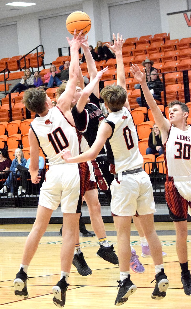 Westside Eagle Observer/MIKE ECKELS
A pride of Lions consisting of Gabe Edgmon (10), Dakota Sizemore (0) and Braxton Muldoon (30) cuts off a Warrior shooter's access to the basket midway through the Gravette-Life Way varsity contest in Gravette Nov. 23.