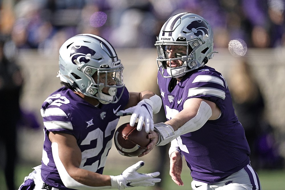 Kansas State quarterback Skylar Thompson, right, hands the ball to running back Deuce Vaughn (22) during the first half of an NCAA college football game against West Virginia, Saturday, Nov. 13, 2021, in Manhattan, Kan. (AP Photo/Charlie Riedel)