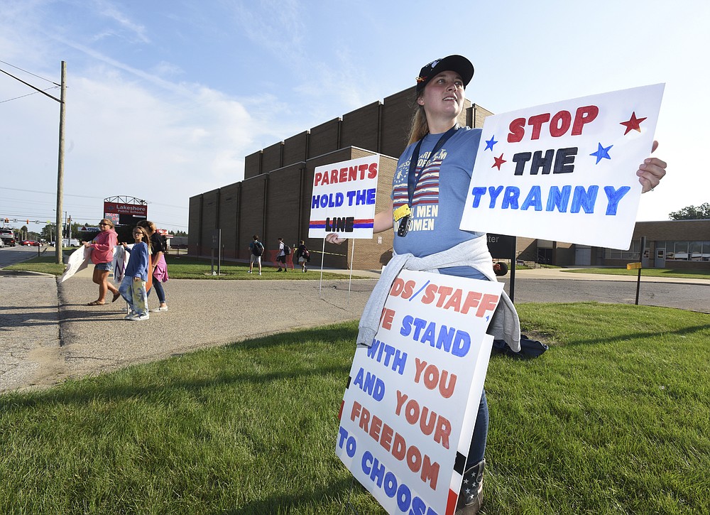 FILE - Hydi Hobbs joins protesters as they gather in front of Lakeshore High School, in Stevensville, Mich., on Sept. 7, 2021, to protest recent COVID-19 mask mandates. Nearly 200 million Americans are fully vaccinated. Yet that still leaves millions without a shot in the arm, at least some of it simply due to defiance. Hospitals in the cold Upper Midwest, especially Michigan and Minnesota, are stuffed with COVID-19 patients who are mostly unvaccinated. (Don Campbell/The Herald-Palladium via AP, File)