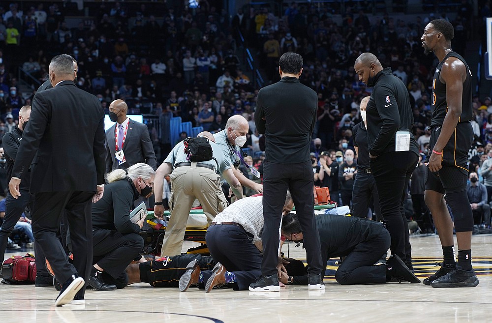 Miami Heat forward Markieff Morris, bottom front, is attended to after he was invovled in an altercation with Denver Nuggets center Nikola Jokic in the second half of an NBA basketball game Monday, Nov. 8, 2021, in Denver. The Nuggets won 113-96. (AP Photo/David Zalubowski)
