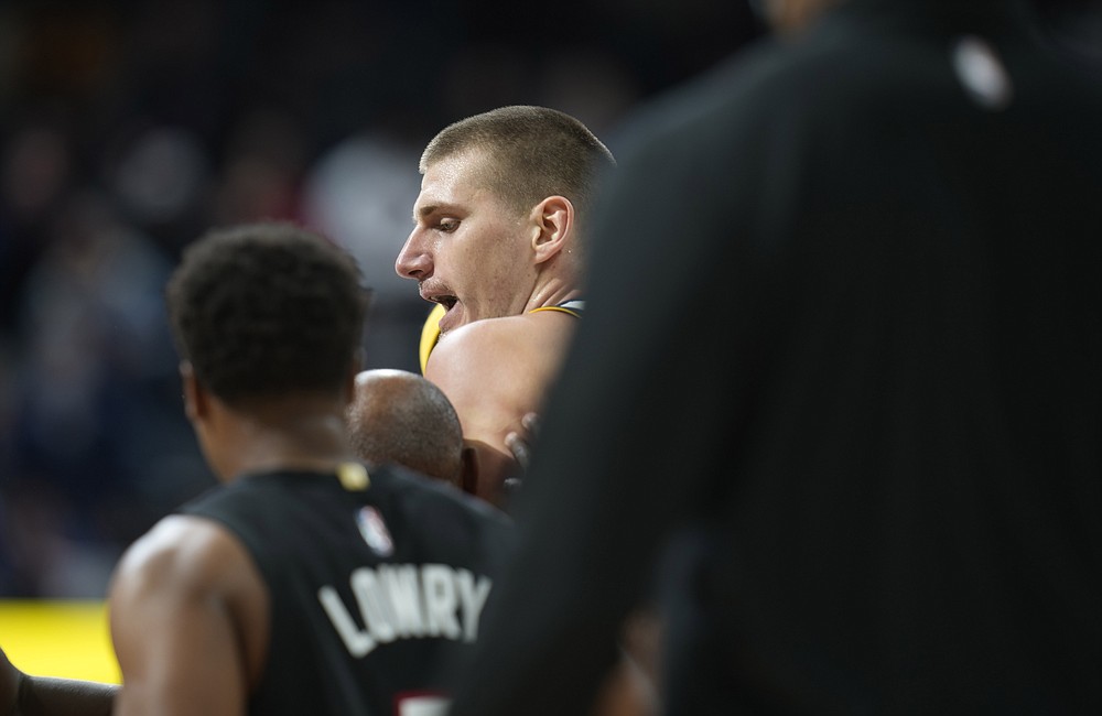 Denver Nuggets center Nikola Jokic, center, is restrained after getting into an altercation with Miami Heat forward Markieff Morris in the second half of an NBA basketball game Monday, Nov. 8, 2021, in Denver. Jokic was ejected for his part in the altercation. (AP Photo/David Zalubowski)