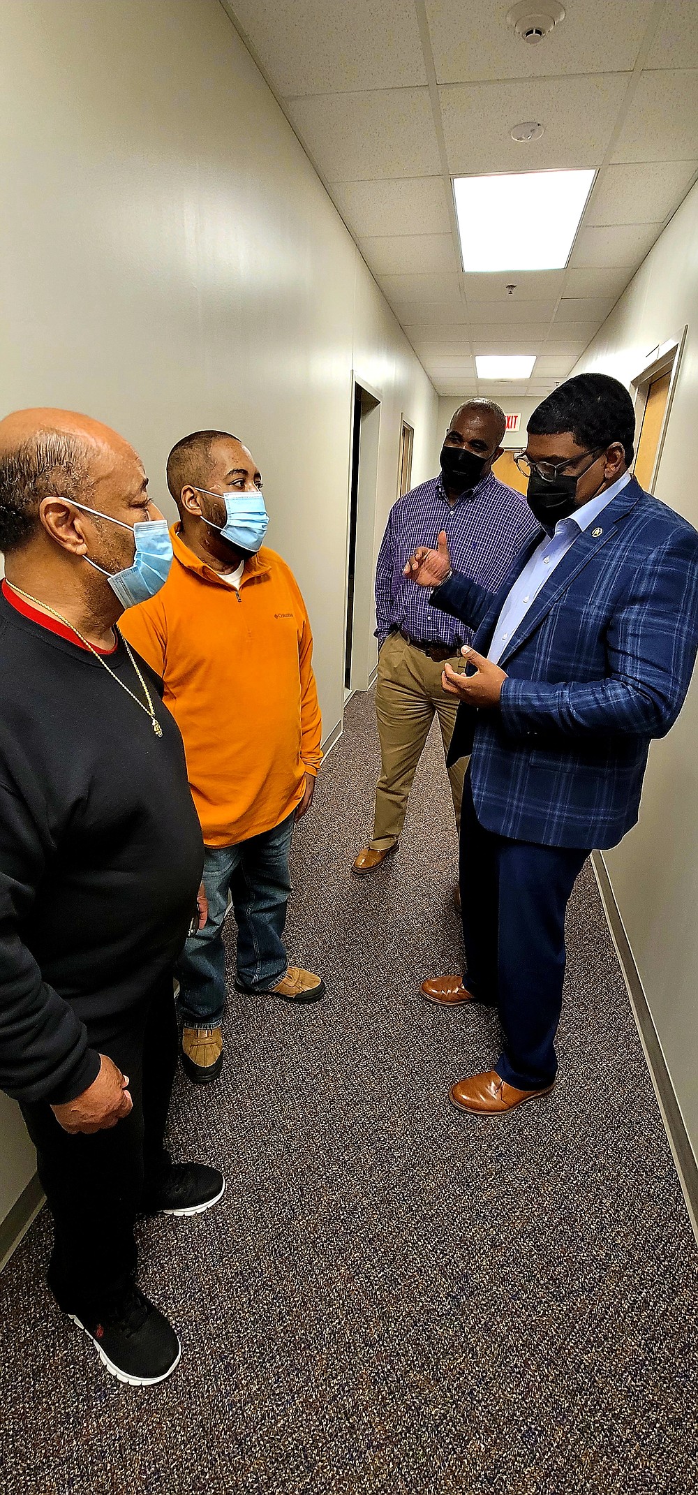 Jefferson County Sheriff Lafayette Woods Jr. (right) and Chief Deputy Stanley James (second from right) tell Lt. Kaylon McDaniel (second from left) how so many people were praying for his recovery. Standing next to McDaniel is his father, Thomas McDaniel. (Pine Bluff Commercial/Eplunus Colvin)