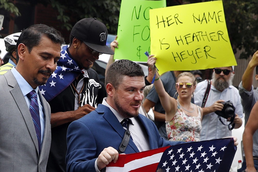 FILE - White nationalist Jason Kessler, center, walks to the White House to rally on the one year anniversary of the Charlottesville "Unite the Right" rally on Aug. 12, 2018, in Washington. A jury ordered white nationalist leaders and organizations to pay more than $25 million in damages Tuesday, Nov. 23, 2021, over violence that erupted during the deadly 2017 Unite the Right rally in Charlottesville. The lawsuit accused some of the country’s most well-known white nationalists of plotting the violence, including Jason Kessler, the rally’s main organizer; Richard Spencer, who coined the term “alt-right” to describe a loosely connected band of white nationalists, neo-Nazis and others; and Christopher Cantwell, a white supremacist who became known as the “crying Nazi” for posting a tearful video when a warrant was issued for his arrest on assault charges for using pepper spray against counterdemonstrators. (AP Photo/Jacquelyn Martin, File)