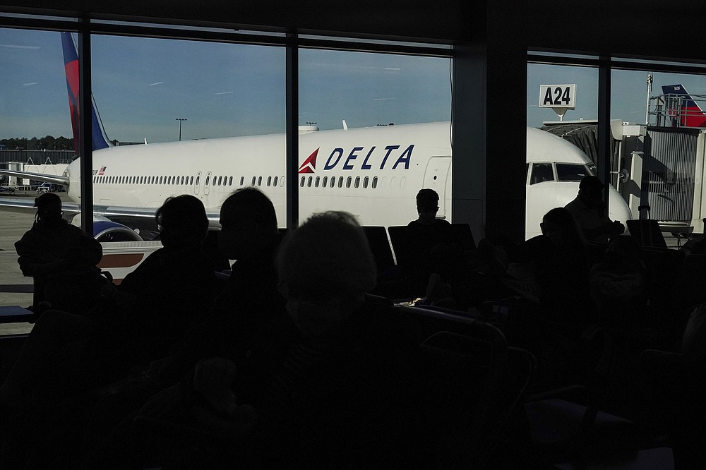 Travelers wait to board their flights at the Hartsfield-Jackson Atlanta International Airport on Tuesday, Nov. 23, 2021, in Atlanta. (AP Photo/Brynn Anderson)