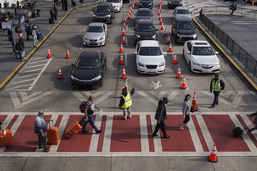 Travelers arrive and depart at the Hartsfield-Jackson Atlanta International Airport on Tuesday, Nov. 23, 2021, in Atlanta. (AP Photo/Brynn Anderson)
