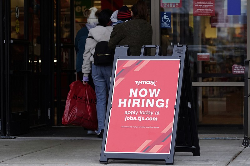 Hiring sign is displayed outside of a retail store in Vernon Hills, Ill., Saturday, Nov. 13, 2021.  The number of Americans applying for unemployment benefits plummeted last week to the lowest level in more than half a century, another sign that the U.S. job market is rebounding rapidly from last year's coronavirus recession.  (AP Photo/Nam Y. Huh)
