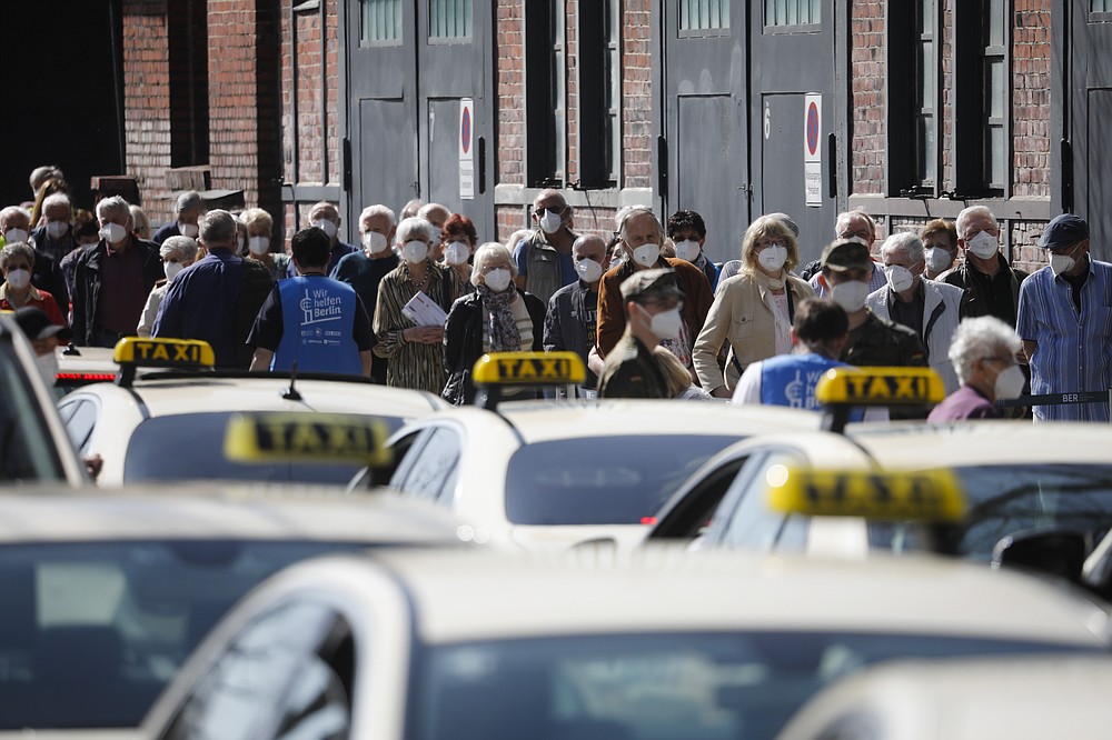 FILE - People line up in front of the vaccination center at the Arena Treptow in Berlin, Germany, March 31, 2021. Germany is set to mark 100,000 deaths from COVID-19 this week, passing a somber milestone that several of its neighbors crossed months ago but which some in Western Europe's most populous nation had hoped to avoid. (AP Photo/Markus Schreiber, File)