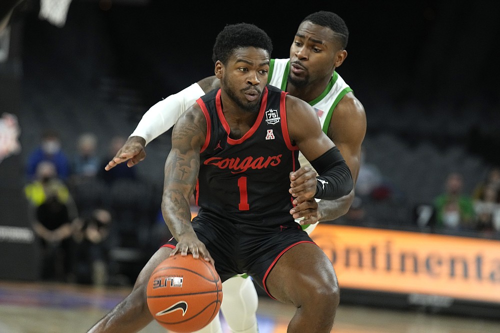 Houston guard Jamal Shead (1) shields the ball from Oregon guard De'Vion Harmon in the first half during an NCAA college basketball game at the Maui Invitational in Las Vegas, Wednesday, Nov. 24, 2021. (AP Photo/Rick Scuteri)