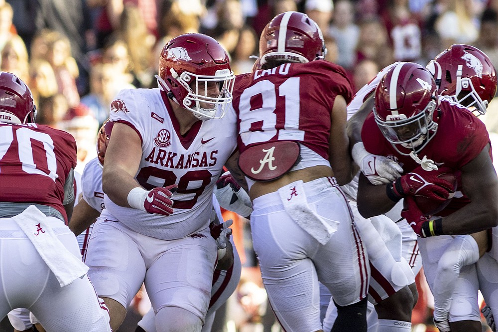 Arkansas defensive lineman John Ridgeway (99) works around Alabama tight end Cameron Latu (81) in pursuit of running back Brian Robinson Jr. (4) during the first half of an NCAA college football game, Saturday, Nov. 20, 2021, in Tuscaloosa, Ala. (AP Photo/Vasha Hunt)