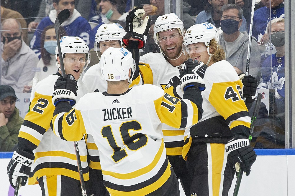 Pittsburgh Penguins' Jeff Carter, second from right, celebrates his goal against the Toronto Maple Leafs with teammates, from left to right, Chad Ruhwedel, Mike Matheson, Jason Zucker and Kasperi Kapanen during first-period NHL hockey game action in Toronto, Saturday, Nov. 20, 2021. (Chris Young/The Canadian Press via AP)