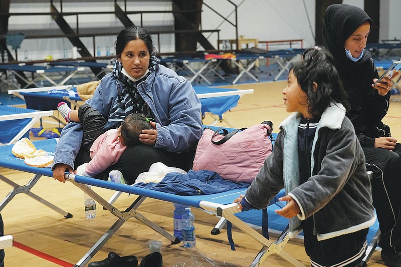 Tooba, left, and Zakia, sister and wife of Hamid wait to leave a temporary shelter set in a gym in Monasterace, Calabria region, Southern Italy, Thursday, Nov. 11, 2021. When the Taliban took Kabul in August, Hamid was working as an auditor, his 24-year-old wife was in her first year of university studying economics. They decided to flee with five other family members beginning a two-month odyssey through Iran and Turkey and across the sea packed below deck on an expensive sailboat that left them on a beach in Calabria on November 10th dehydrated, hungry and wet, but alive and relieved to be in Europe. (AP Photo/Alessandra Tarantino)