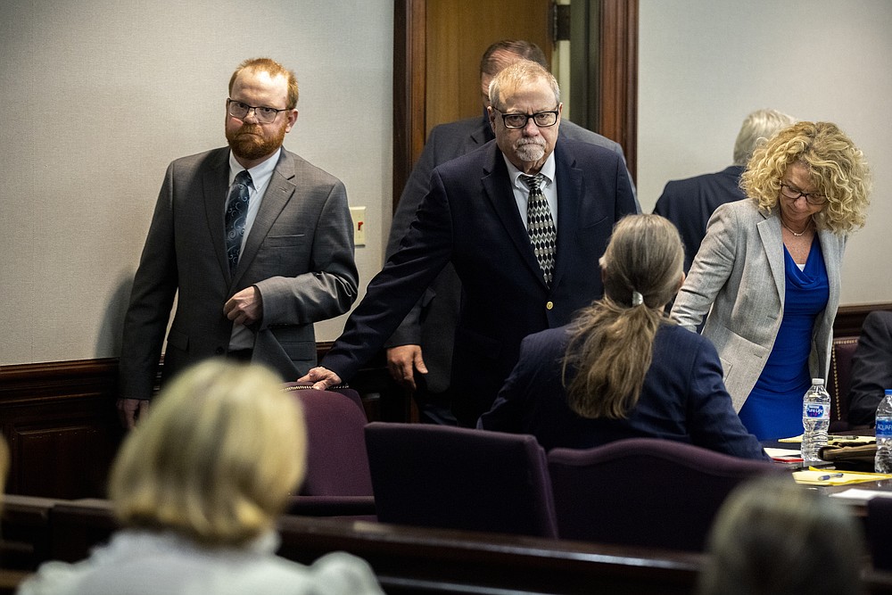 Greg McMichael, center, and his son, Travis McMichael, left,, look at family members seated in the gallery when they walk into the courtroom for the reading of the jury's verdict in the Glynn County Courthouse, Wednesday, Nov. 24, 2021, in Brunswick, Ga. McMichael and his son, Travis McMichael, and a neighbor, William "Roddie" Bryan, charged in the death of Ahmaud Arbery were convicted of murder Wednesday in the fatal shooting that became part of a larger national reckoning on racial injustice.(AP Photo/Stephen B. Morton, Pool)