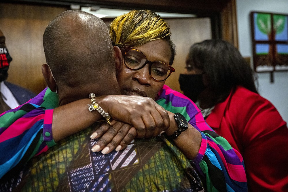 Ahmaud Arbery's mother, Wanda Cooper-Jones his hugged by a supporter after the jury convicted Travis McMichael in the trial of McMichael, his father, Greg McMichael, and neighbor, William "Roddie" Bryan, Wednesday, Nov. 24, 2021, in the Glynn County Courthouse in Brunswick, Ga. The three defendants were found guilty Wednesday in the death of Ahmaud Arbery. (AP Photo/Stephen B. Morton, Pool)