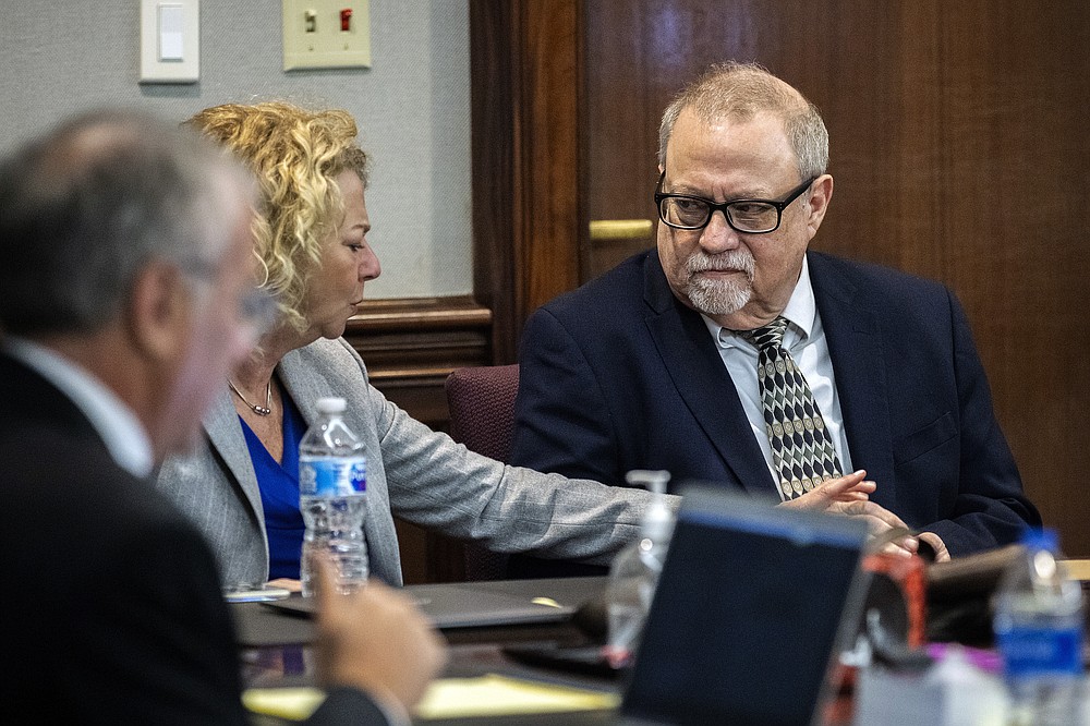 Defense attorney Laura Hogue, center, touches the hand of her client Greg McMichael, right, while they wait for the jury to come into to the courtroom during the trial of McMichel and his son, Travis McMichael, and a neighbor, William "Roddie" Bryan in the Glynn County Courthouse, Wednesday, Nov. 24, 2021, in Brunswick, Ga. The three are charged with the February 2020 slaying of 25-year-old Ahmaud Arbery. (AP Photo/Stephen B. Morton, Pool)