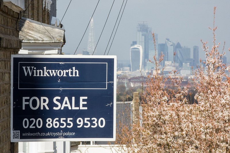 A sign advertising a property for sale hangs from the side of a building against a backdrop of the city of London on March 26, 2019. MUST CREDIT: Bloomberg photo by Chris Ratcliffe