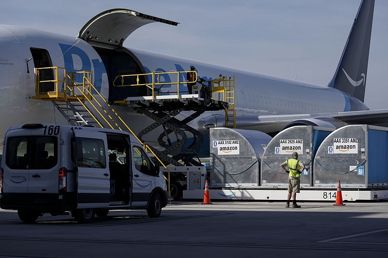 Grounds crew members load cargo into an Amazon Prime Air aircraft at the company's Air Hub at the Cincinnati/Northern Kentucky International Airport (CVG) in Hebron, Ky., on Oct. 11, 2021. MUST CREDIT: Bloomberg photo by Jeffrey Dean.