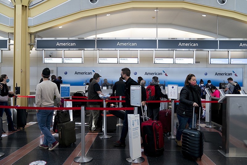 Travelers wait in line at an American Airlines kiosk at Reagan National Airport on Sunday. MUST CREDIT: photo for The Washington Post by Stefani Reynolds.