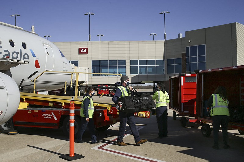 Airport grounds crew unload baggage from a parked airplane in January at Northwest Arkansas National Airport in Highfill. Go to nwaonline.com/211128Daily/ for today's photo gallery. 
(File Photo/NWA Democrat-Gazette/Charlie Kaijo)