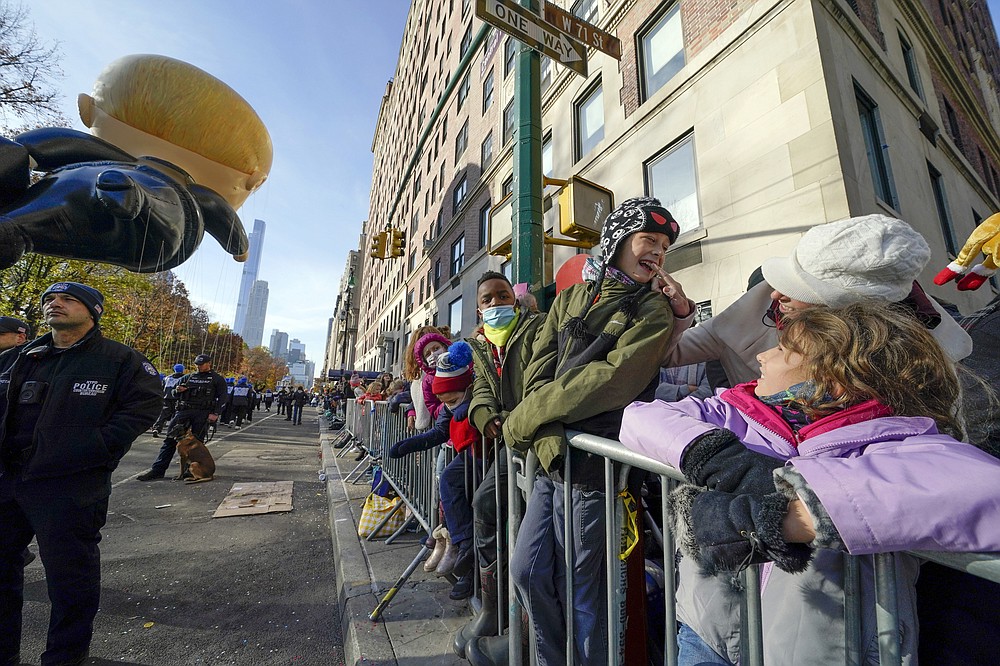 People watch as the Macy's Thanksgiving Day Parade passes by, Thursday, Nov. 25, 2021, in New York. The parade is returning in full, after being crimped by the coronavirus pandemic last year. (AP Photo/Seth Wenig)