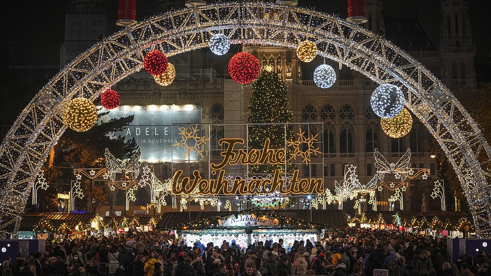 FILE - People crowd a Christmas market in Vienna, Austria, Nov. 21, 2021. Despite the pandemic inconveniences, stall owners selling ornaments, roasted chestnuts and other holiday-themed items in Frankfurt and other European cities are relieved to be open at all for their first Christmas market in two years, especially with new restrictions taking effect in Germany, Austria and other countries as COVID-19 infections hit record highs. (AP Photo/Vadim Ghirda, File)