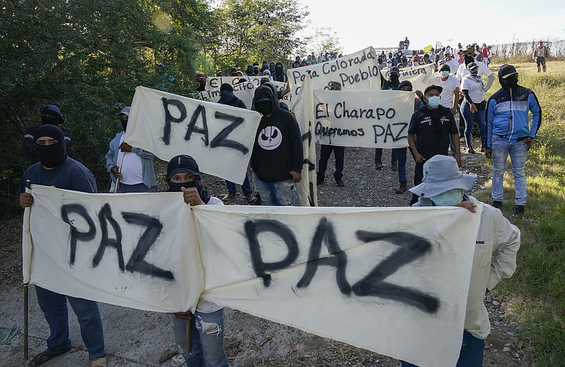 Residents of Aguililla and other nearby communities who are fed up with the army&#x2019;s strategy of simply separating the Jalisco and the Michoacan-based Viagras gangs, march against roadblocks in Loma Blanca, Mexico, Tuesday, Nov. 16, 2021. The army policy effectively allows the Viagras, best known for kidnapping and extorting money, to set up roadblocks and checkpoints that have choked off all commerce with Aguililla. Limes and cattle heading out, or supplies heading in, must pay a war tax to the Viagras. (AP Photo/Eduardo Verdugo)