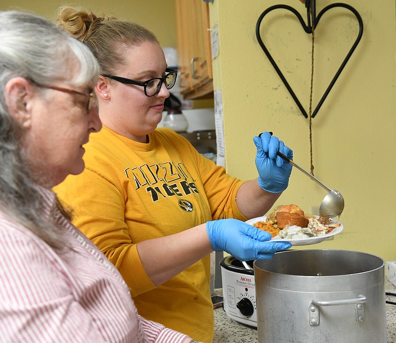 Hannah Bailes, kitchen manager at Samaritan Ministries, 131 Sanford St., fills a plate for their annual Thanksgiving meal on Friday as Jan Laggan, left, co-founder and executive director, assists. - Photo by Tanner Newton of The Sentinel-Record