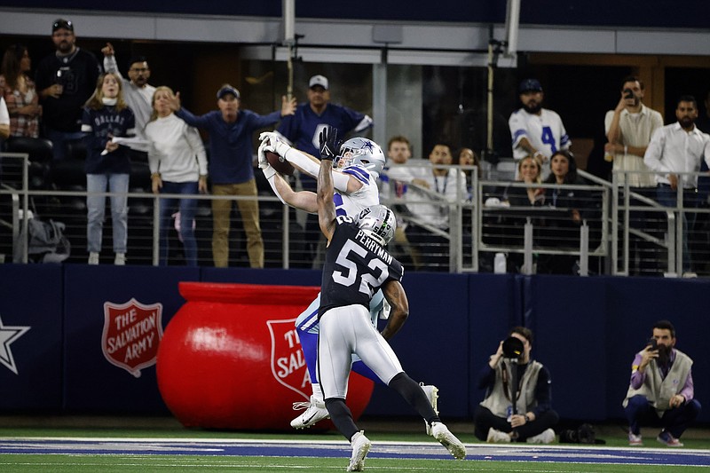 Fans look on as Dallas Cowboys tight end Dalton Schultz catches a touchdown pass in front of Las Vegas Raiders linebacker Denzel Perryman (52) in the second half of an NFL football game in Arlington, Texas, Thursday, Nov. 25, 2021. (AP Photo/Michael Ainsworth)