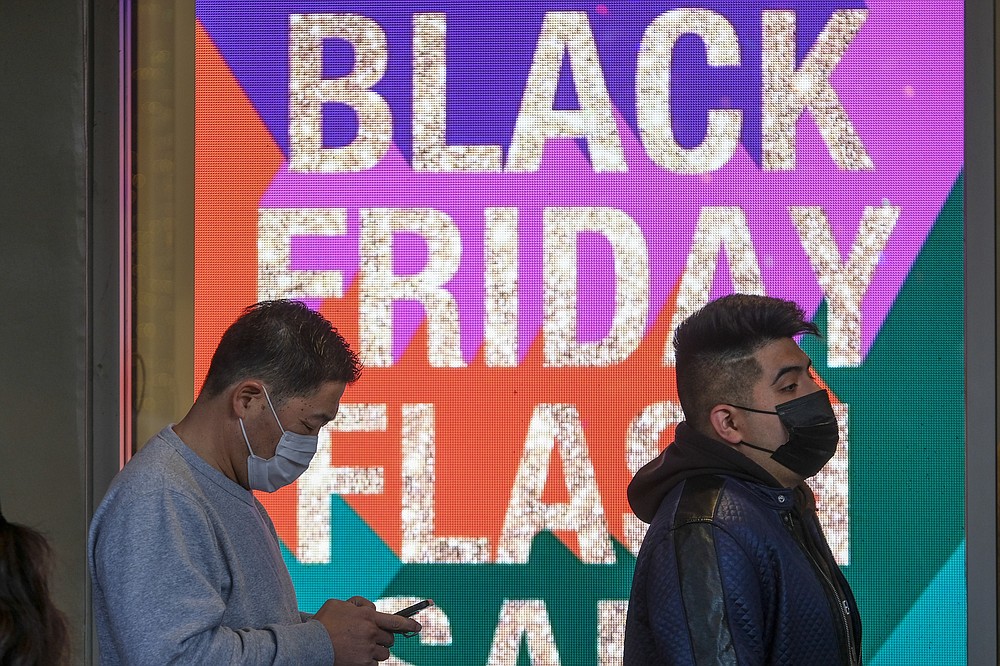 Black Friday shoppers, wearing face masks, wait in line to enter a store at the Citadel Outlets in Commerce, Calif., Friday, Nov. 26, 2021. (AP Photo/Ringo H.W. Chiu)