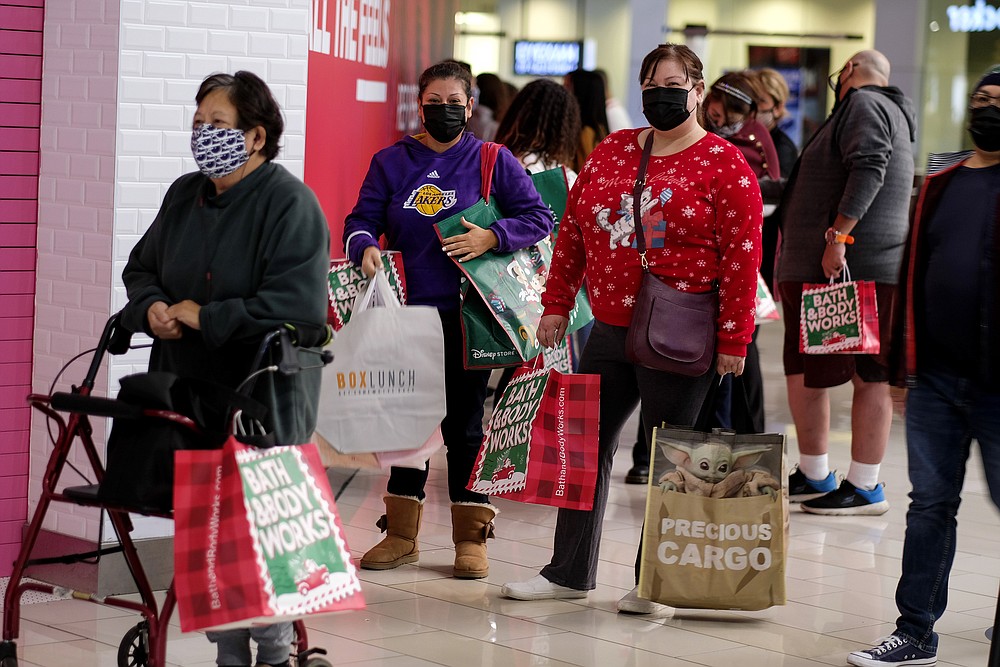 FILE - Black Friday shoppers wearing face masks wait in line to enter a store at the Glendale Galleria in Glendale, Calif., Friday, Nov. 27, 2020. Retailers are expected to usher in the unofficial start to the holiday shopping season Friday, Nov. 26, 2021, with bigger crowds than last year in a closer step toward normalcy. But the fallout from the pandemic continues to weigh on businesses and shoppers&#x27; minds. (AP Photo/Ringo H.W. Chiu, File)