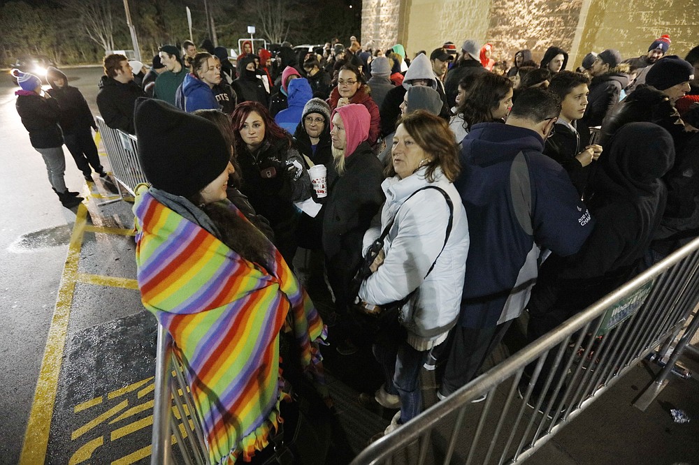 FILE - Shoppers wait for doors to open at Walmart on Black Friday, in Dartmouth, Mass., on Nov. 25, 2016. Retailers are expected to usher in the unofficial start to the holiday shopping season Friday, Nov. 26, 2021, with bigger crowds than last year in a closer step toward normalcy. (Peter Pereira/The Standard-Times/SCMGs via AP, File)