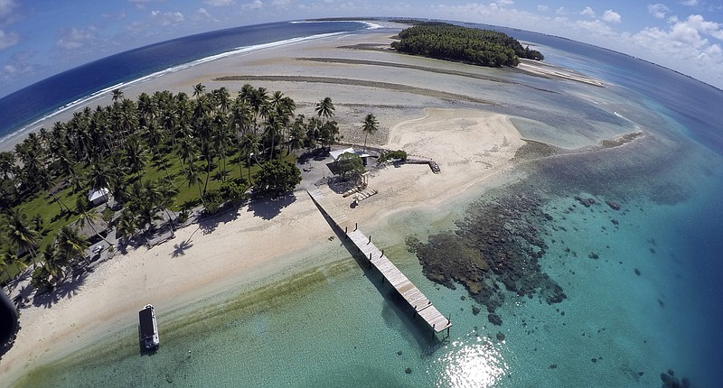 An aerial photo shows a small section of the atoll that has slipped beneath the water line only showing a small pile of rocks at low tide on Majuro Atoll in the Marshall Islands on Nov. 8. For decades, the tiny Marshall Islands has been a stalwart American ally. Its location in the middle of the Pacific Ocean has made it a key strategic outpost for the U.S. military. - AP Photo/Rob Griffith