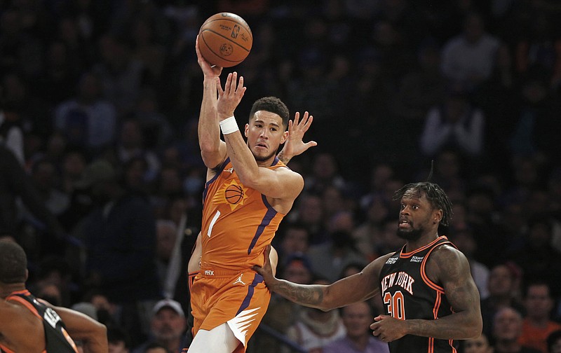 Phoenix Suns' Devin Booker (1) looks to pass over New York Knicks' Julius Randle (30) during the first half of an NBA game Friday in New York. - Photo by John Munson of The Associated Press