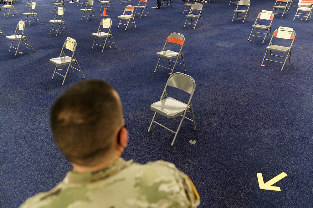 FILE - Rhode Island Army National Guard Sgt. Juan Gomez looks over the post-inoculation waiting area at a coronavirus mass-vaccination site at the former Citizens Bank headquarters in Cranston, R.I., June 10, 2021. The coronavirus challenge has proved to be vexing for the White House, with last summer&amp;#x2019;s premature claims of victory swamped by the more transmissible delta variant, stubborn millions of Americans unvaccinated and lingering economic effects from the pandemic&#x27;s darkest days. All of that as yet another variant of the virus emerged overseas, omicron, spreading fresh fears among public health officials, sparking new travel bans and panicking markets at week&#x27;s end as scientists raced to understand how dangerous it may be. (AP Photo/David Goldman, File)
