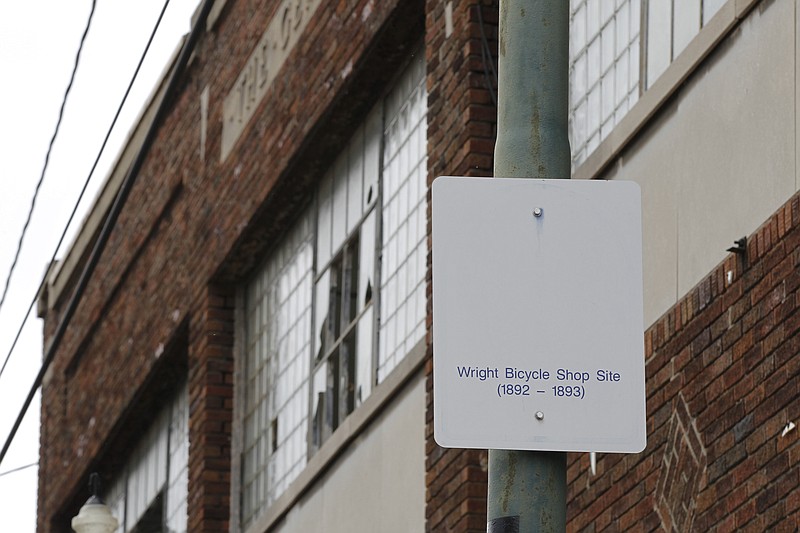 FILE - In this undated photo, a sign notes the site of the Wright brothers' bike shop outside the former Gem City Ice Cream building in Dayton, Ohio.  The Dayton Board of Zoning Appeals has approved the city&#x2019;s request to demolish a 129-year-old historic building that once was the site of the Wright brothers&#x2019; first bike shop. The city wants to tear down the site because the building has deteriorated to a point where it can no longer be maintained and redeveloped. (Ty Greenlees/Dayton Daily News via AP, File)